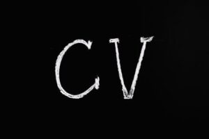 Chalk text 'CV' on a black chalkboard. Ideal for resume or education-related themes.